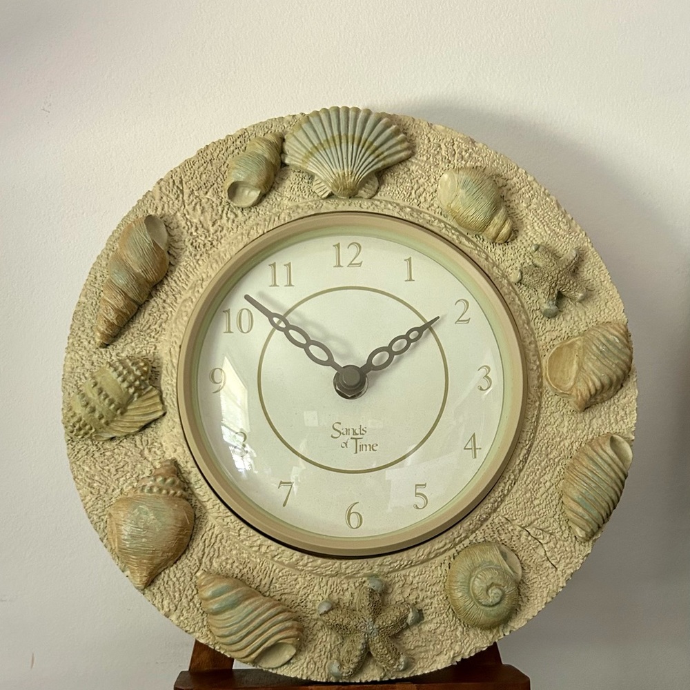 Sands of Time 9” wall clock. Stone like material with seashell decoration. Works
